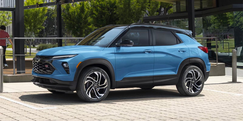 A Chevrolet Trailblazer parked in front of a modern building, showcasing its sleek design and vibrant color.